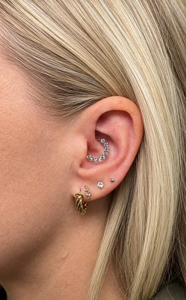 Piercing daith con aro de circonitas y varios piercings en el lóbulo