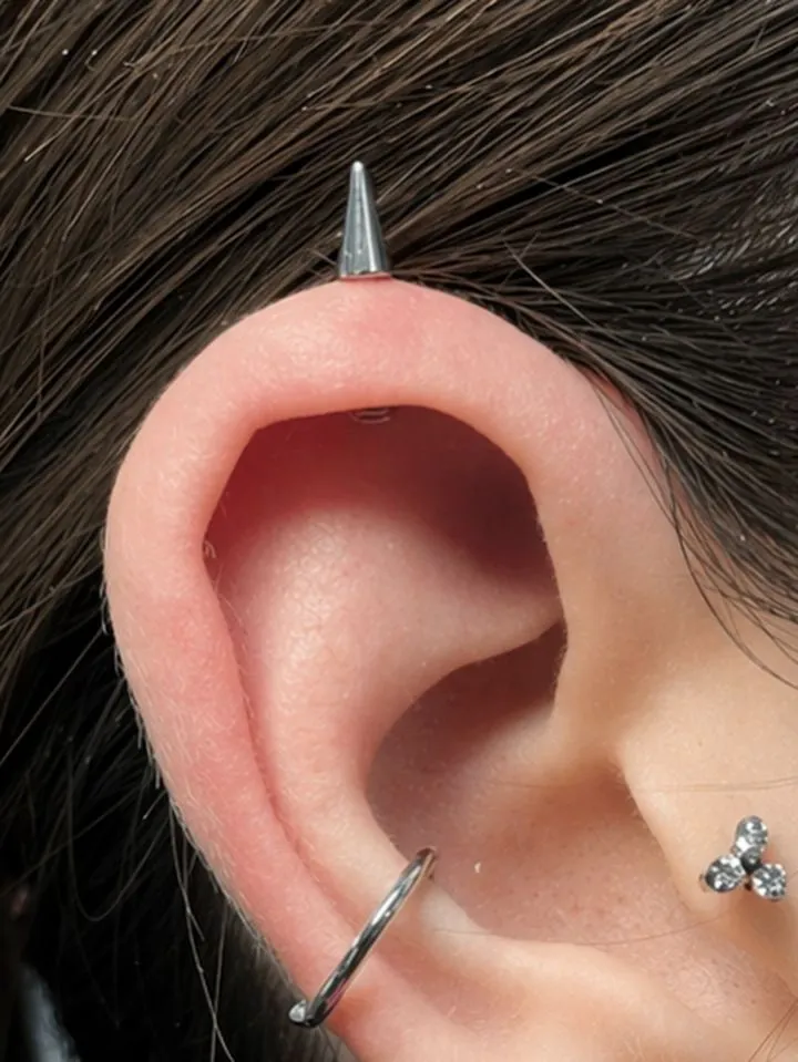 Piercing de hélix con pincho y aro en la oreja