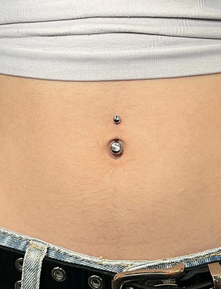 Piercing de ombligo con joyería de titanio y circonitas