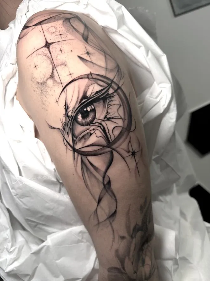 Tatuaje de un ojo con estrellas en negro y gris