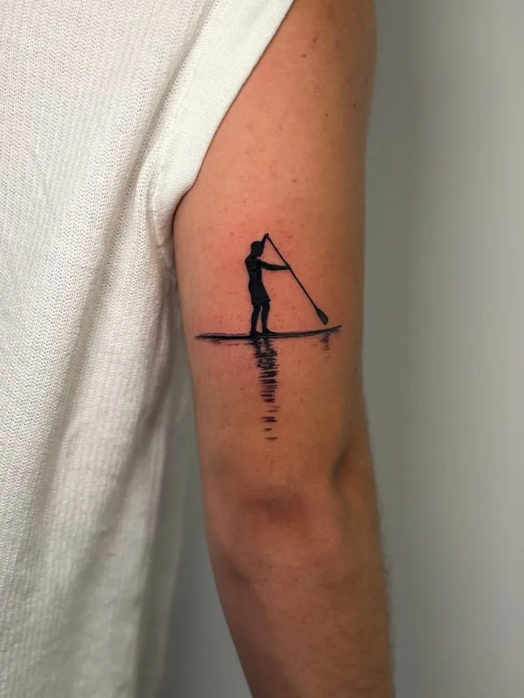 Tatuaje de una persona en paddle surf en silueta negra