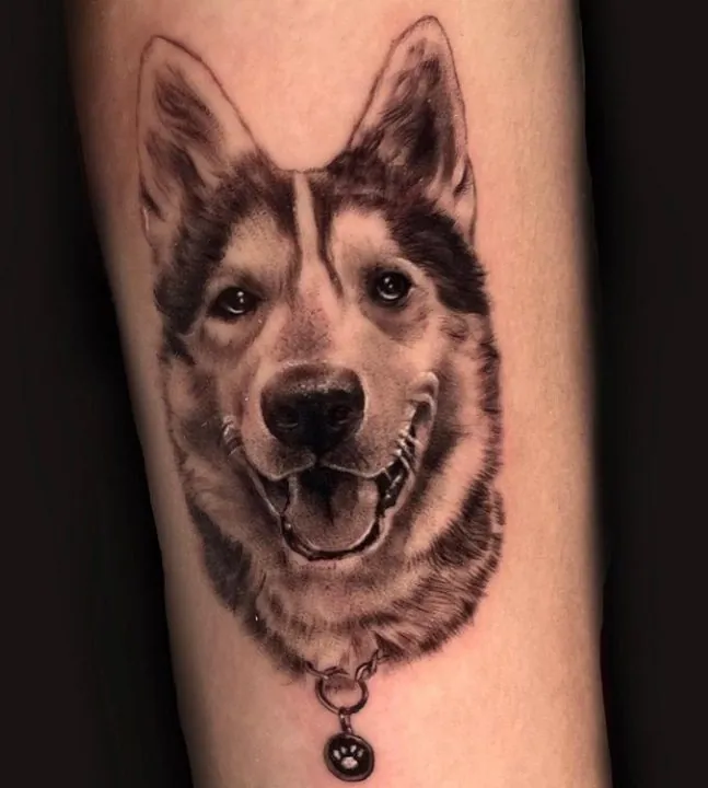Tatuaje realista de un perro husky con chapa de huella