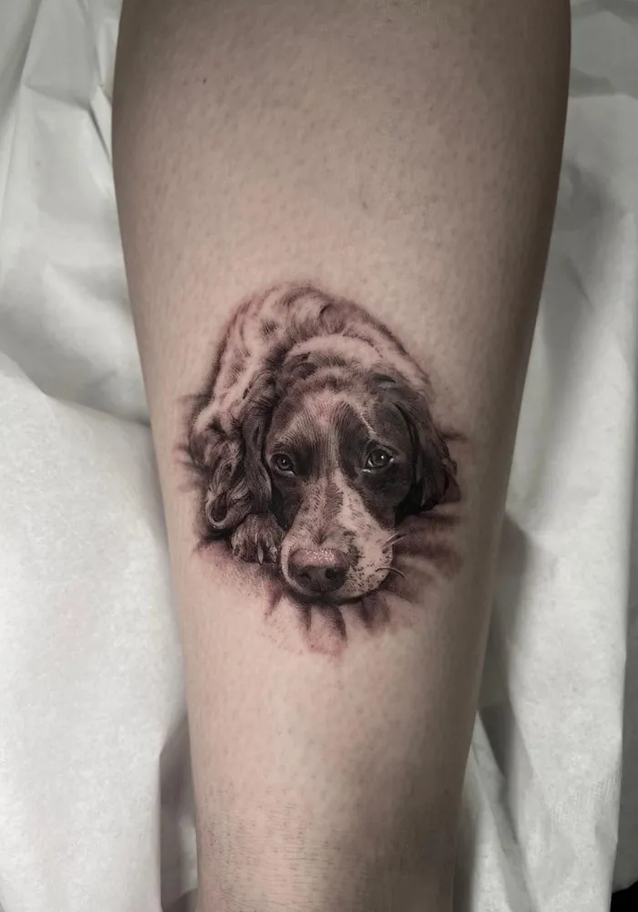 Tatuaje realista de un perro tumbado