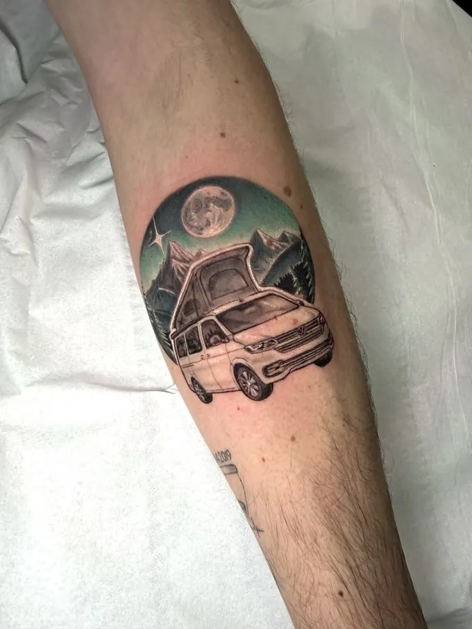 Tatuaje realista de una furgoneta camper bajo la luna